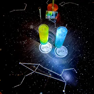 星座の上で光る2杯のドリンクとSPICAのコースター