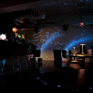 惑星のランプと星座の投影に包まれた店内