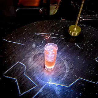 星座が映るテーブルの上で光るドリンク