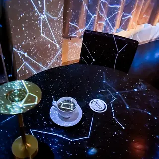 テーブルの上まで星座が投影された客席