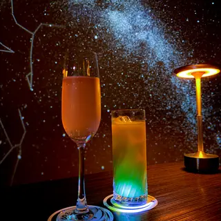 天の川の投影の前に並ぶカクテルとノンアルコールドリンク
