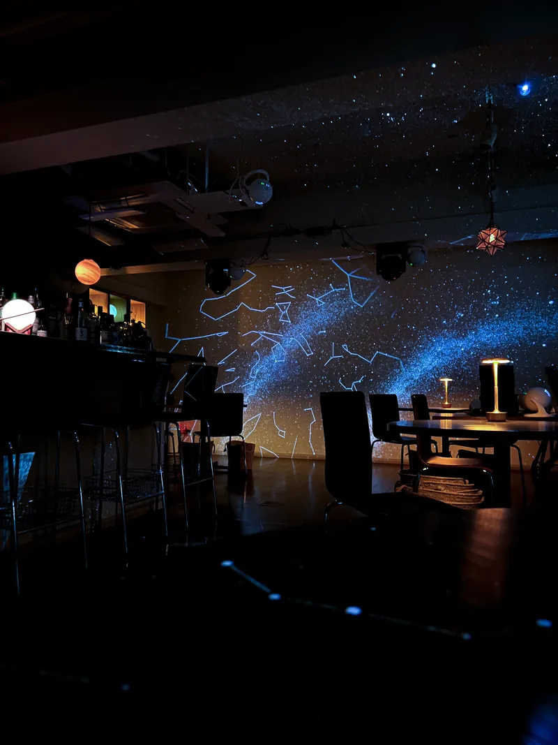 惑星のランプと星座の投影に包まれた店内